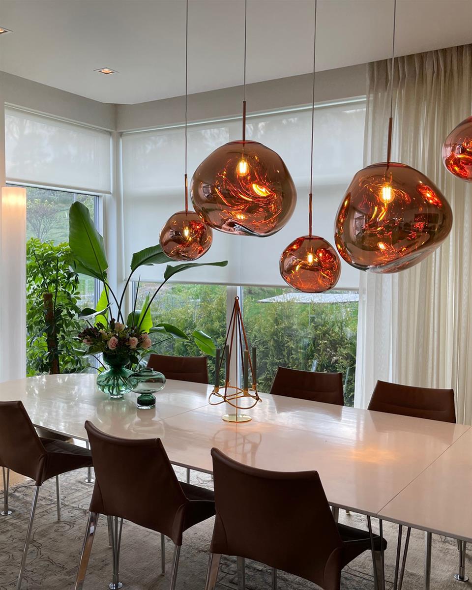 Lyst rom med lysfiltrerende smart rullegardin og hvitt spisebord. Foto.
